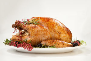 A picture containing plate, fully cooked turkey with trimmings, table, and white background